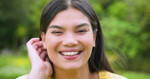 Joyful Woman Smiling in Sunny Garden Wearing Yellow Knit Sweater