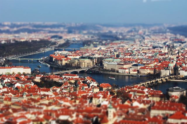 Capturing the beautiful aerial view of Prague, showcasing its famous Charles Bridge and historical architecture along the Vltava River. The view features vivid red rooftops and significant landmarks of the Czech Republic’s capital city. This can be used for travel blogs, tourism promotions, and architectural appreciation websites highlighting European cities.
