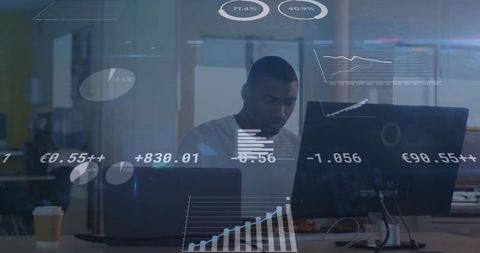 Focused professional analyzing data on dual monitors with digital graphics