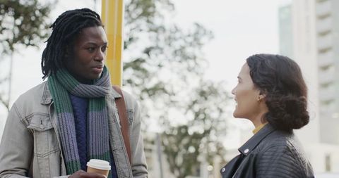 Urban Morning Conversation: African American Man and Woman Commuting with Coffee