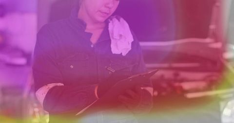 Experienced female mechanic analyzing engine in auto workshop