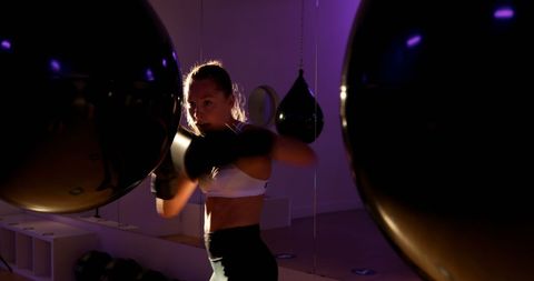 Determined female boxer practicing in fitness studio