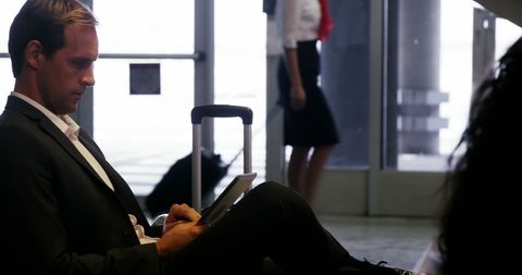 Business Traveler Using Tablet at Airport Terminal