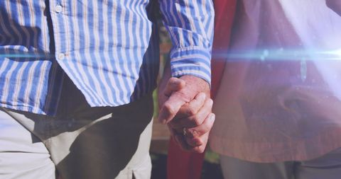 Senior Couple Holding Hands Under Sunlight