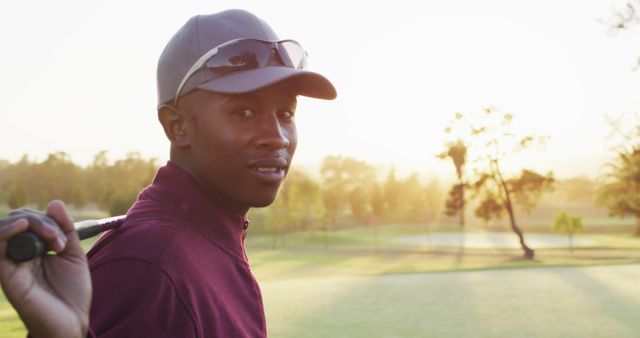 Image of african american man holding golf club on golf field. sporty, active lifestyle and playing golf concept.