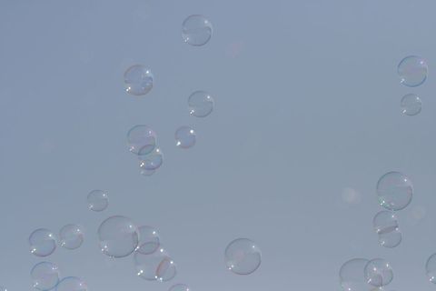 Floating Bubbles Against Clear Blue Sky