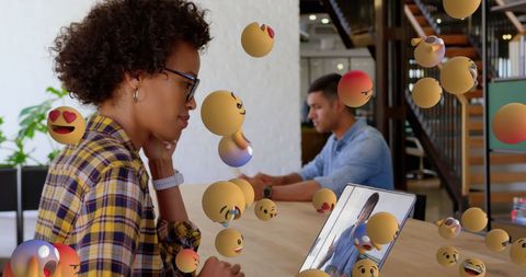 African American Woman Using Laptop with Floating Emojis in Modern Office - Download Free Stock Images Pikwizard.com