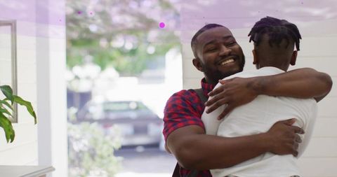 Father hugging son in home entryway showing warm welcome and genuine family affection