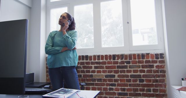 Businesswoman on Phone in Spacious Modern Office with Brick Wall - Download Free Stock Images Pikwizard.com