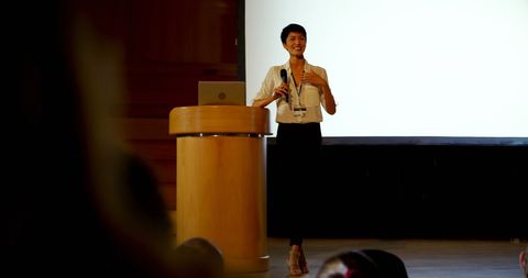 Smiling Asian Businesswoman Speaking at Conference