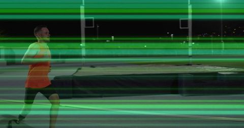 Night runner sprinting with neon green light streaks on outdoor track, copy space