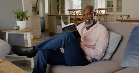 Mature Man Reading Book at Home Relaxing with Comfort and Leisure