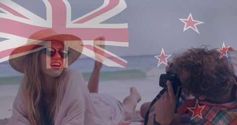 Relaxing couple enjoying beach photography under new zealand flag overlay