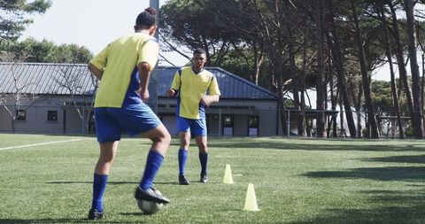Soccer Players Practicing Dribbling on Sunny Field