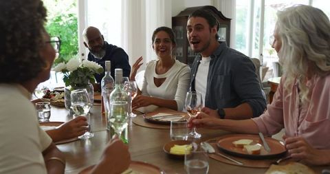Friends Celebrating with Laughter at Elegant Wedding Reception Table