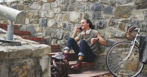 Fashionable mixed-race man talking on smartphone outdoors