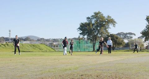 Women's Cricket Team Competitively Playing on Sunny Day
