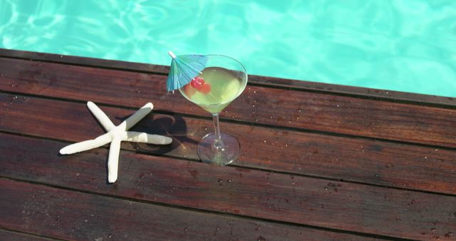 Cocktail glass and fake starfish near swimming pool at spa house 4k