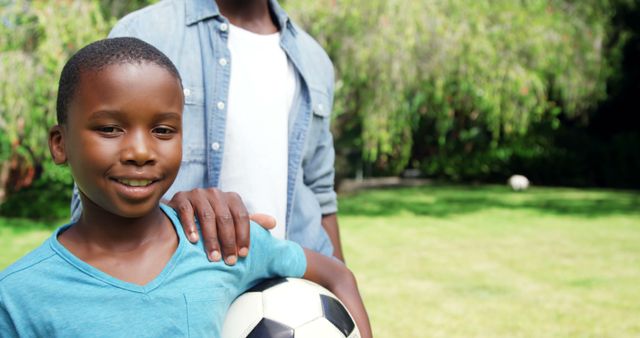 Smiling Boy Holding Soccer Ball With Father Outdoors - Download Free Stock Images Pikwizard.com