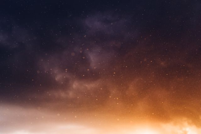 This photo depicts a dreamy sunset sky with an abstract combination of light particles. The gradient blends from a dark, twilight color in the upper sky to a warm, golden hue towards the horizon. Ideal for use in digital backgrounds, motivational posters, and relaxation or meditation content.
