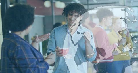 Curly-haired professional chatting over coffee with badge in office lounge, map overlay