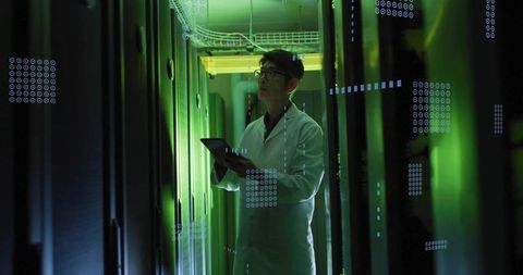 Korean IT engineer inspecting data center racks with tablet under green lighting