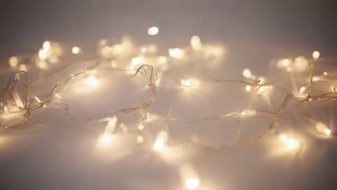Cinematic warm fairy lights drifting across tabletop with soft bokeh and copper wire glow