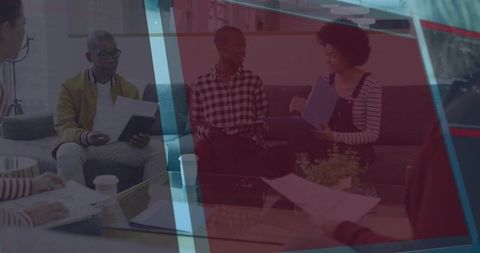 Colleagues collaborating in relaxed modern lounge holding folders around glass table