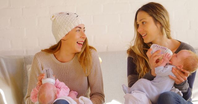 Two Mothers Feeding Babies with Bottles, Smiling and Bonding - Download Free Stock Images Pikwizard.com