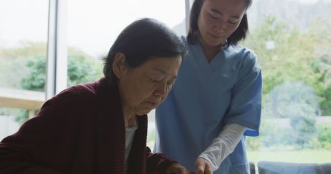 Dedicated Nurse Assists Elderly Patient with Walking Aid