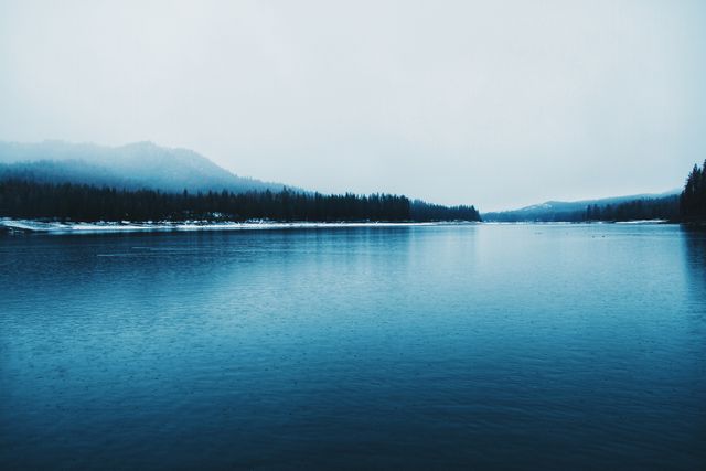 Serene Mountain Lake in Winter with Foggy Forest - Download Free Stock Photos Pikwizard.com