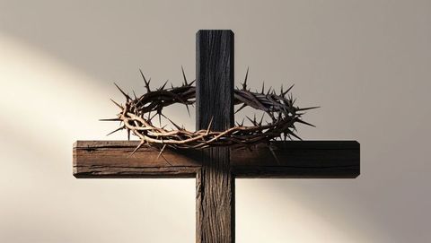 Wooden cross with crown of thorns in beam of light symbolizing jesus' sacrifice