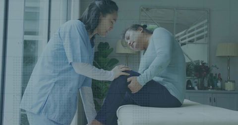 Physiotherapist Consulting Patient with Knee Pain in Clinic