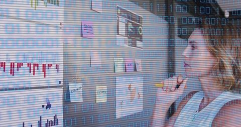 Businesswoman Analyzing Data Charts on Office Board