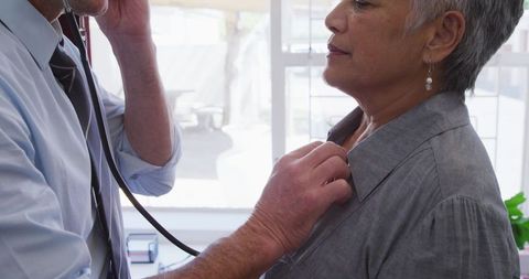 Doctor Examines Senior Patient with Stethoscope in Medical Clinic
