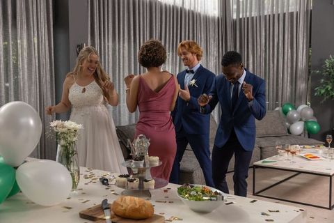 Cheerful Bridal Party Dancing at Reception with Decorations