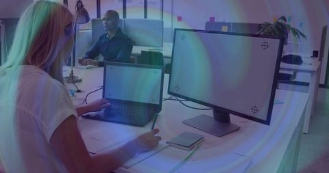 Modern coworking desk with woman typing on laptop and taking notes, minimalist office space