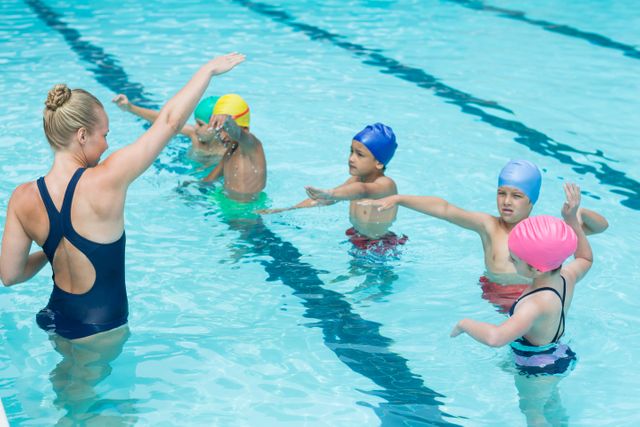 Female Trainer Instructing Children in Swimming Pool - Download Free Stock Photos Pikwizard.com