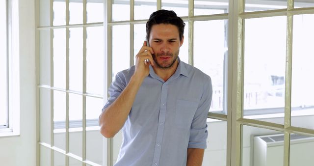 Stressed Businessman Talking on Smartphone in Bright Office - Download Free Stock Images Pikwizard.com