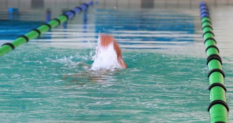 Swimmer Performing Backstroke in Indoor Pool
