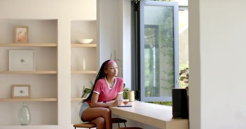 Young Woman Relaxing with Coffee at Bright Contemporary Home - Download Free Stock Images Pikwizard.com
