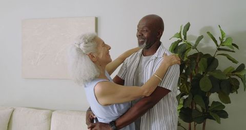 Senior Couple Embracing in Living Room While Dancing