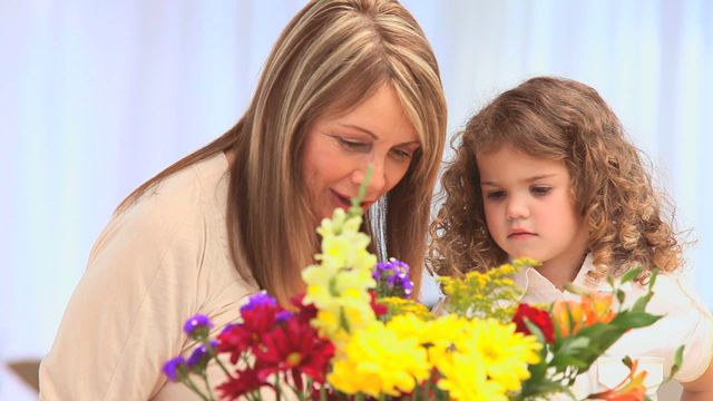 Grandmother and granddaughter creating flower arrangement with various colorful flowers. Scene captures cherished bond and joy of crafting together, surrounded by vibrant flowers. Ideal for depicting family, creativity, and intergenerational activities. Useful in blogs, articles, and marketing that focus on family ties, creative projects, and home dynamics.