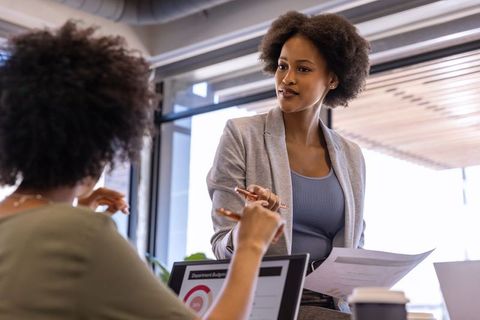 Confident Female Leader Collaborating on Budget Presentation at Modern Office