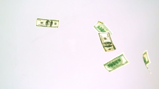 Currency bills are falling against a plain white background in slow motion, creating a mesmerizing visual. This can be used in financial content to symbolize wealth, economic themes, or monetary freedom. Perfect for advertisements, articles on financial success, and videos discussing income or expenses.