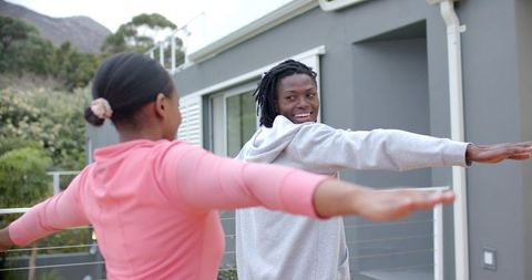 African American Couple Stretching Together on Modern Home Terrace During Morning Workout