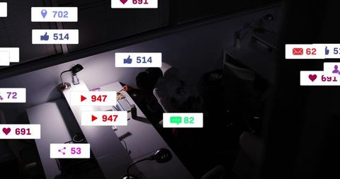 Diverse women collaborating late at office desk with social media metric badges