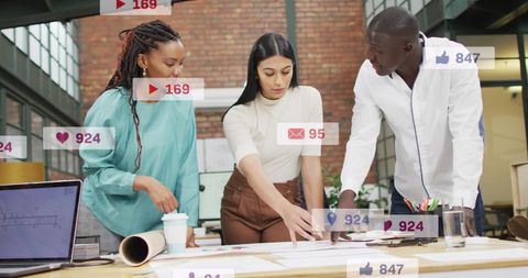 Diverse Team Analyzing Plan with Social Media Notifications Displayed