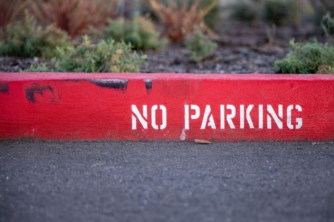 Red no parking curb with stencil letters