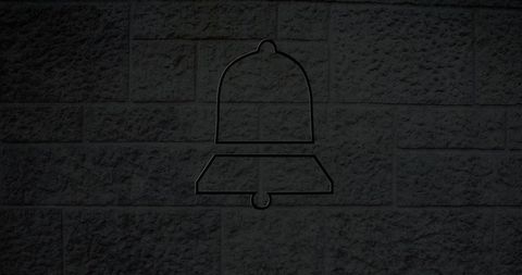 Glowing neon bell icon on brick wall